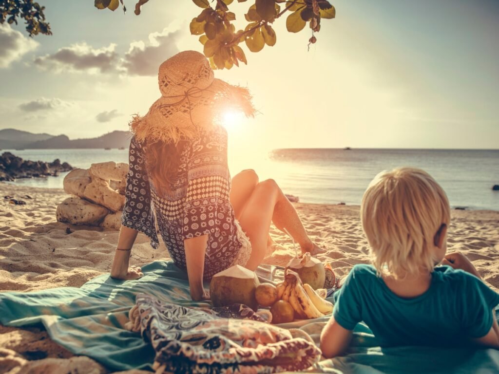 Family picnic on the beach - Image by VladGans from Getty Images Signature - Best Beach Activities for Kids