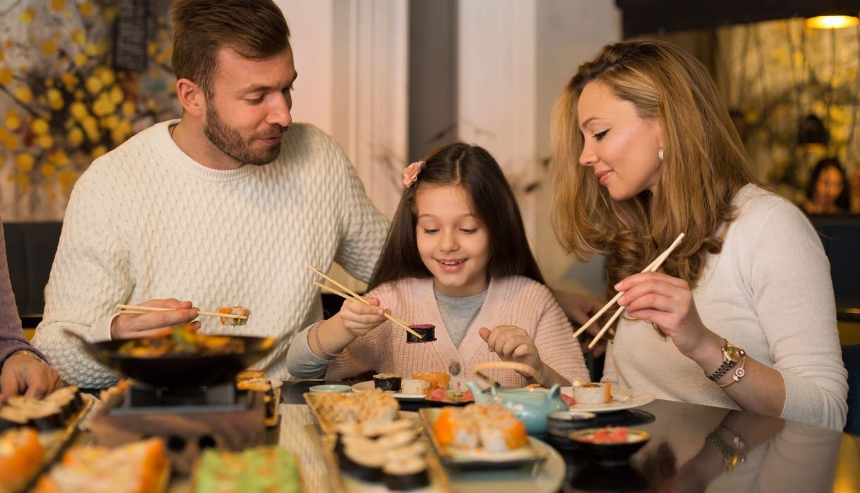 Sushi Restaurants in Huntsville - Family eating sushi_ - Image by GoodLifeStudio from Getty Images Signature