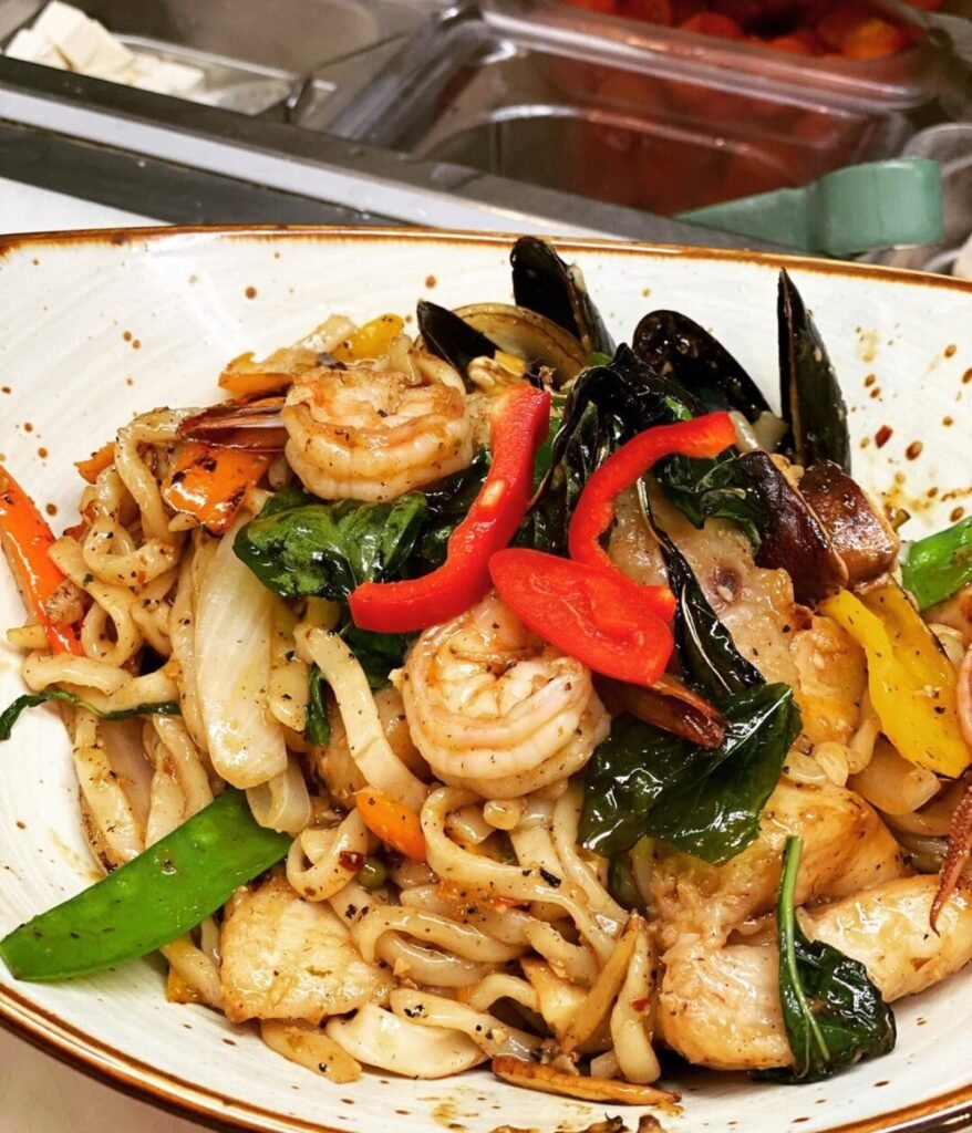 Spicy seafood garlic noodles and crispy soft-shell crab at Thai Basil in Sacramento, CA Image from Instagram